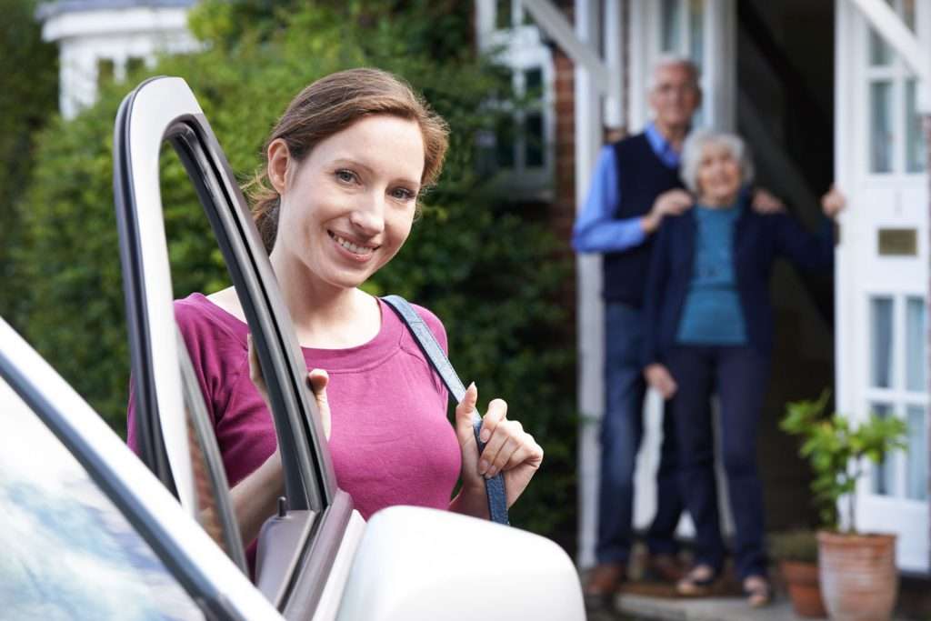 A caregiver arriving at a home which is equipped with a portable senior toilet.